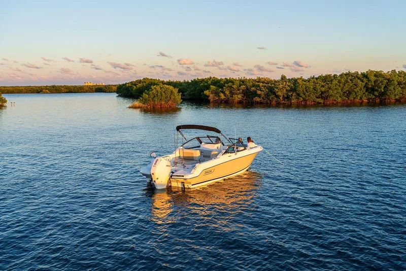 Slide: The Image of 2024 Boston Whaler 210 Vantage boat on serene water at sunset. - 3