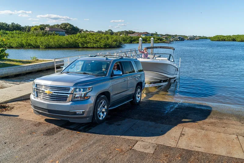 Slide: The Image of SUV towing a 2024 Boston Whaler 210 Vantage boat into the water at a boat ramp. - 34