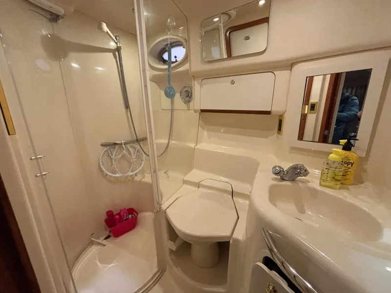 Slide: The Image of 1999 Sea Ray Sundancer 450 bathroom with shower, sink, and toilet. - 36