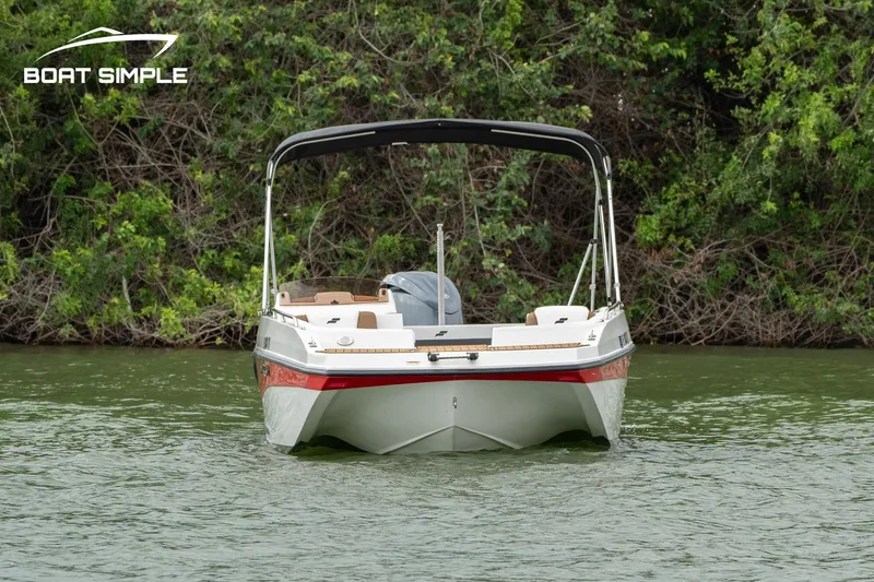 Slide: The Image of 2024 Starcraft SVX 211 OB boat on a calm lake, surrounded by lush greenery. - 2