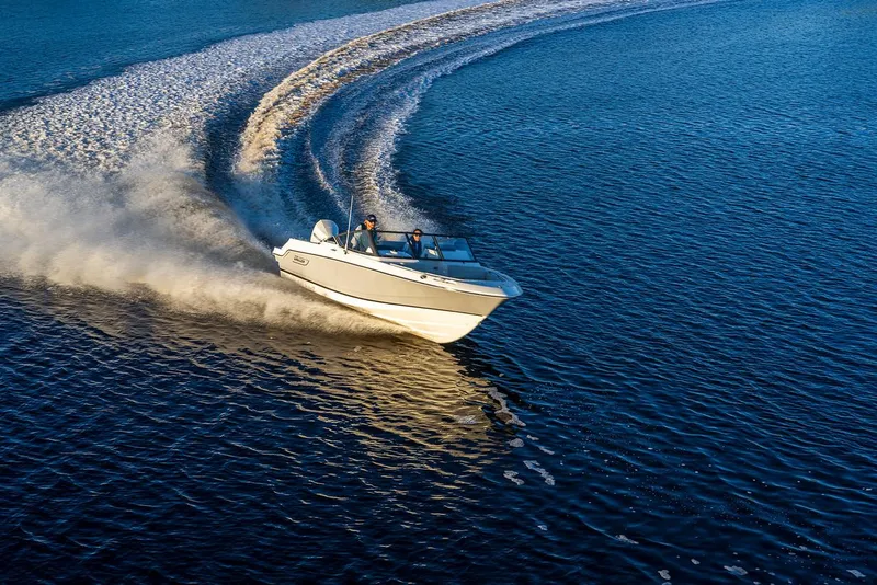 Slide: The Image of 2025 Boston Whaler 210 Vantage cruising on open water, creating a dynamic wake. - 12