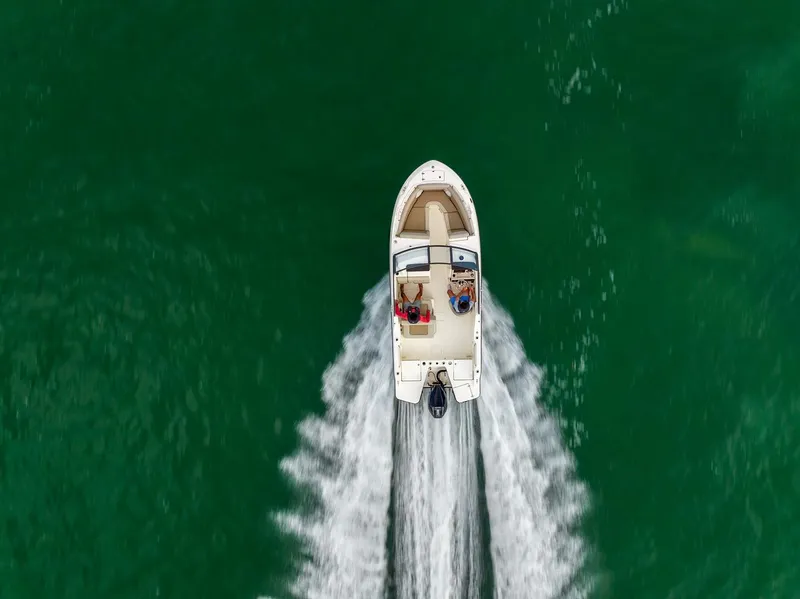 Slide: The Image of 2025 Boston Whaler 210 Vantage cruising on open water, aerial view. - 25