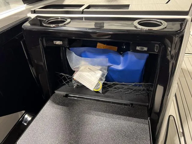 Slide: The Image of 2025 Yamaha Boats 222SD storage compartment with cup holders and accessories. - 14