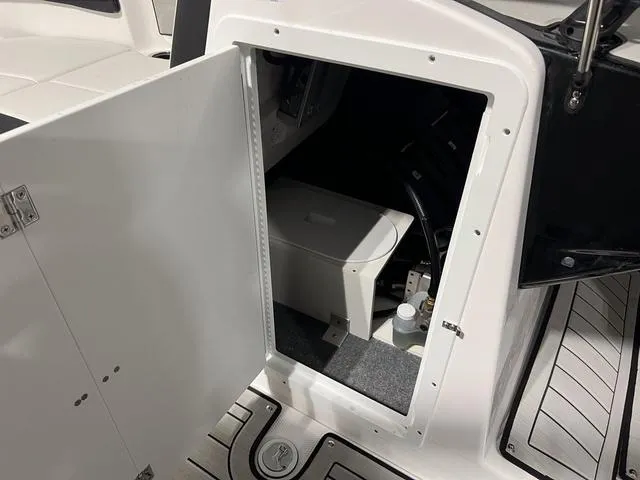Slide: The Image of 2025 Yamaha Boats 222SD storage compartment with open door, revealing interior details. - 23