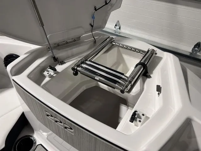 Slide: The Image of 2025 Yamaha Boats 222SD storage compartment with foldable ladder. - 30