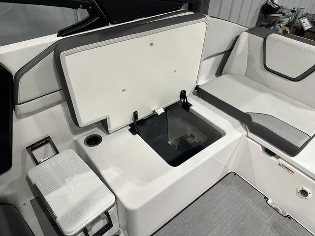 Slide: The Image of 2025 Yamaha Boats AR250 interior seating with storage compartment open. - 13
