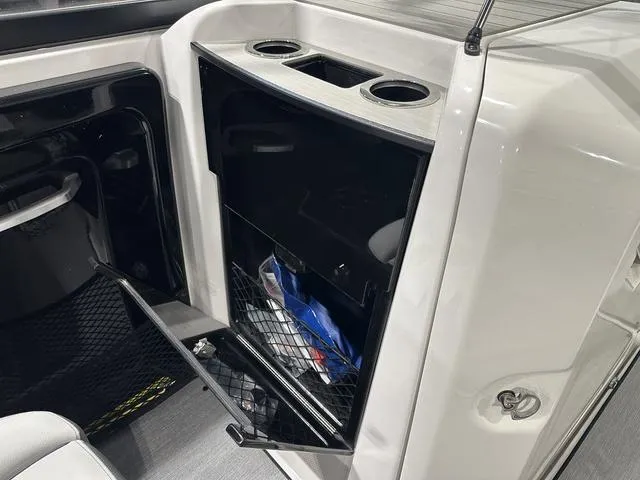 Slide: The Image of 2025 Yamaha AR250 boat interior with open storage compartment and cup holders. - 17