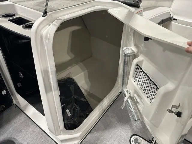 Slide: The Image of 2025 Yamaha AR250 boat storage compartment with open door and interior view. - 20