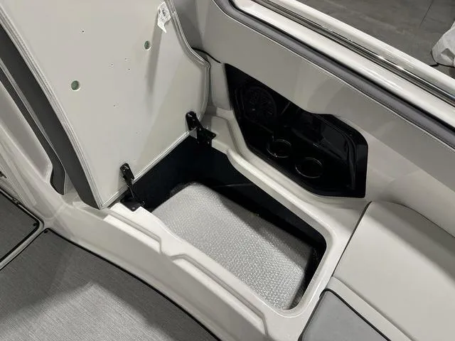 Slide: The Image of 2025 Yamaha AR250 boat interior storage compartment with cup holders. - 23