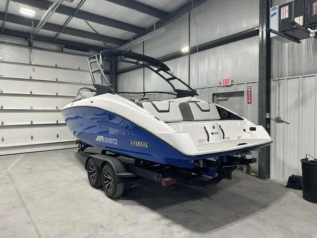 Slide: The Image of 2025 Yamaha AR250 boat in garage, blue and white design, on trailer. - 5