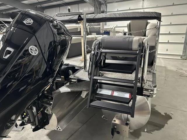 Slide: The Image of 2025 Barletta Cabrio C22M boat with motor and seating in a garage. - 7