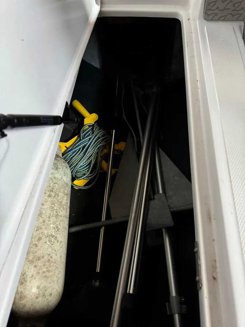 Slide: The Image of 2010 Nautique Sport Nautique 226 storage compartment with equipment and rope. - 16