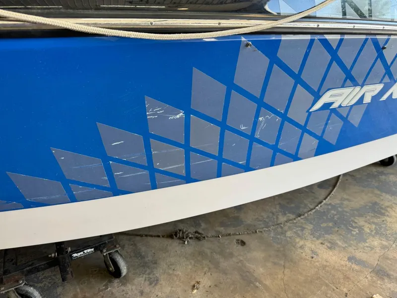 Slide: The Image of 2010 Nautique Sport Nautique 226 boat with blue geometric design and visible scratches. - 22