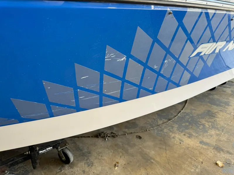 Slide: The Image of 2010 Nautique Sport Nautique 226 boat with blue geometric design and visible scratches. - 24