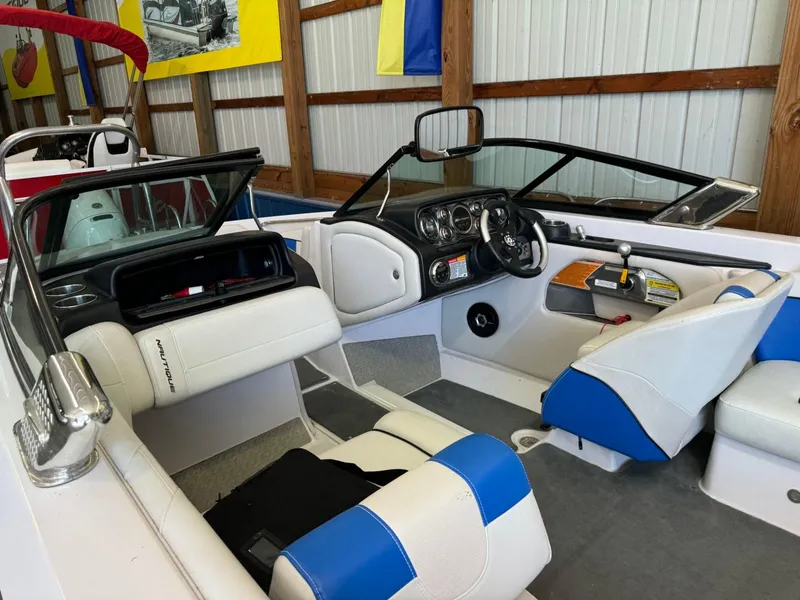 Slide: The Image of 2010 Nautique Sport Nautique 226 boat interior with blue and white seating. - 25