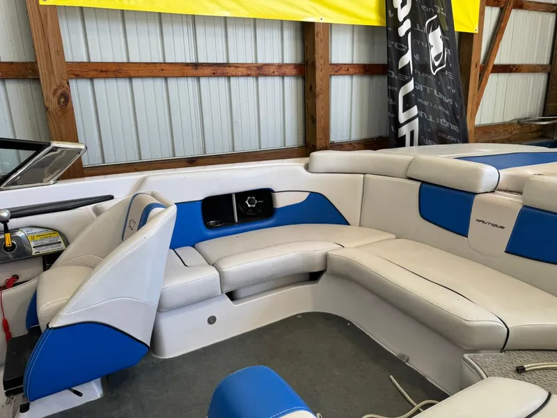Slide: The Image of 2010 Nautique Sport Nautique 226 boat interior with blue and white seating. - 26