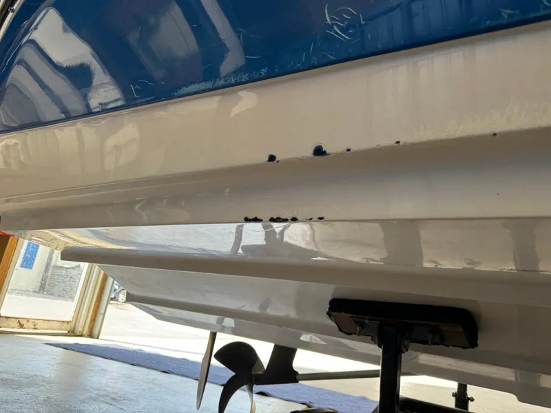 Slide: The Image of 2010 Nautique Sport Nautique 226 boat hull with minor damage in a garage setting. - 35