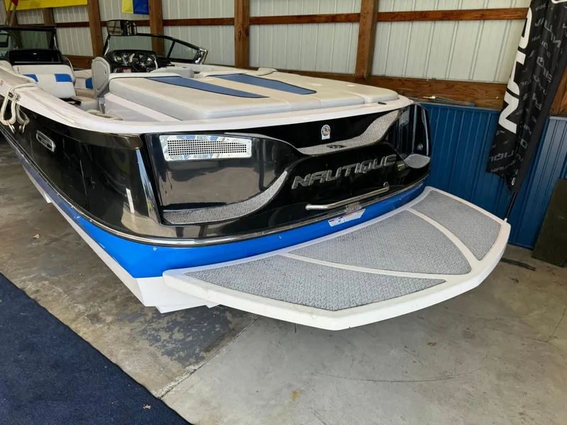 Slide: The Image of 2010 Nautique Sport Nautique 226 boat in a garage, featuring sleek black and blue design. - 37