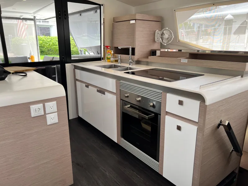 Slide: The Image of Luxurious interior of 2022 Fountaine Pajot Aura 51 catamaran with modern kitchen and seating area. - 14