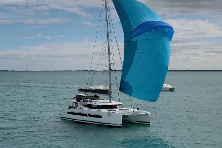 Slide: The Image of 2022 Fountaine Pajot Aura 51 catamaran docked in a marina, surrounded by other boats. - 2
