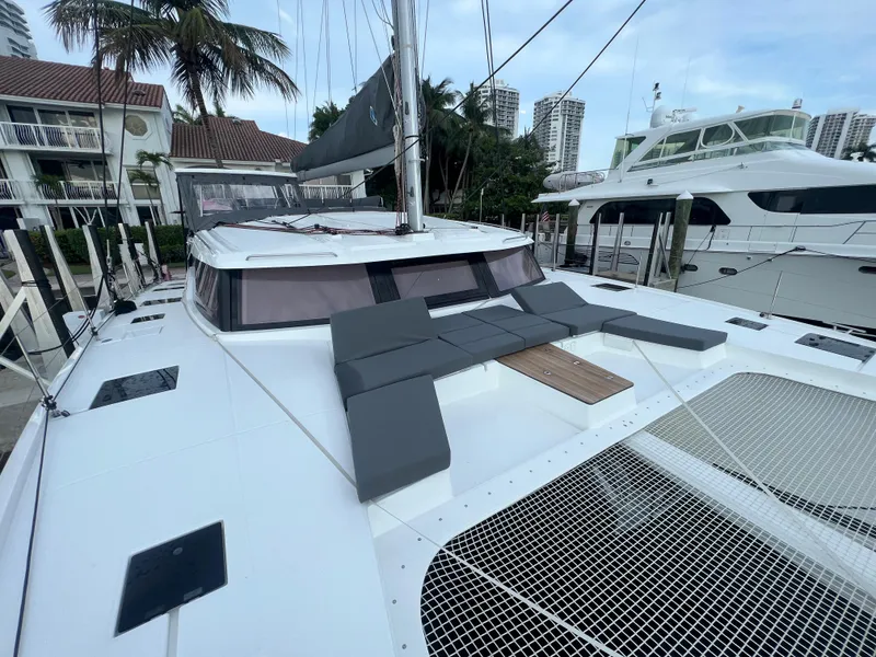 Slide: The Image of Fountaine Pajot Aura 51 catamaran, 2022 model, docked in a marina with other boats. - 64