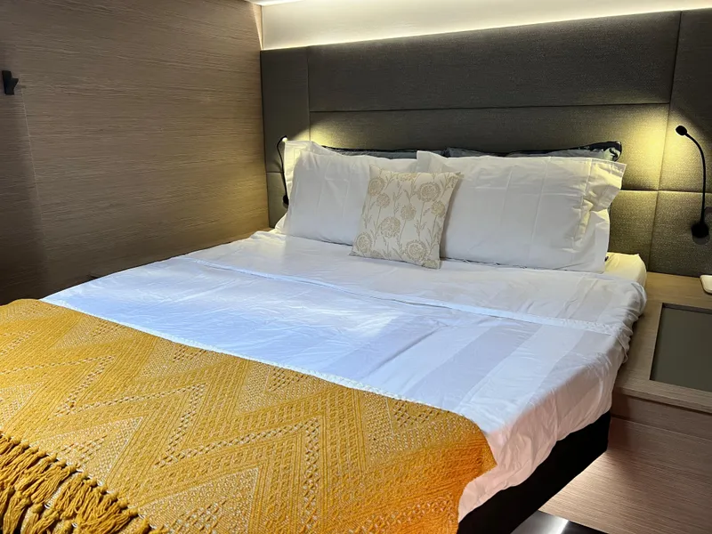 Slide: The Image of 2022 Fountaine Pajot Aura 51 catamaran with netted deck, docked at a serene marina. - 50