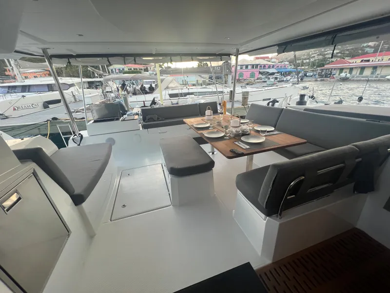 Slide: The Image of 2022 Fountaine Pajot Aura 51 yacht docked at night with vibrant blue underwater lights. - 54