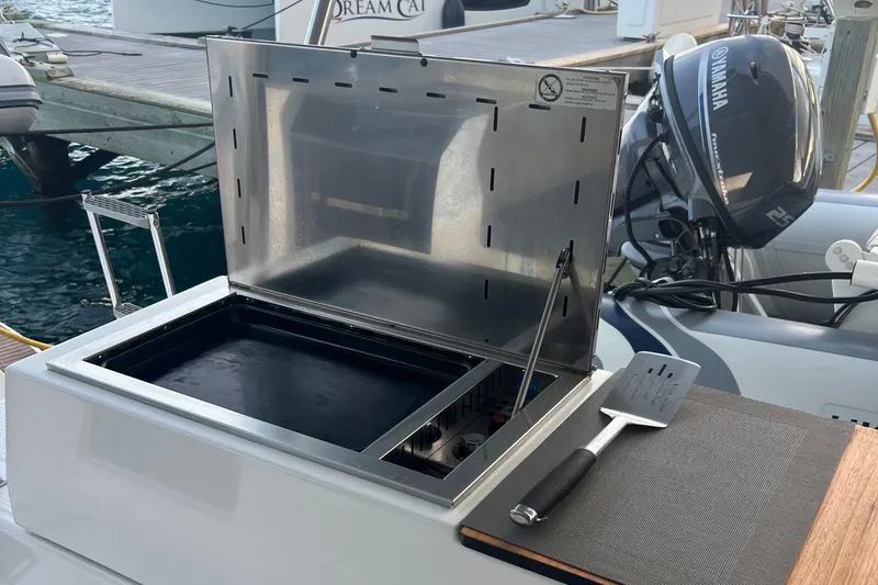 Slide: The Image of 2022 Fountaine Pajot Aura 51 catamaran sailing with a blue spinnaker on open water. - 55