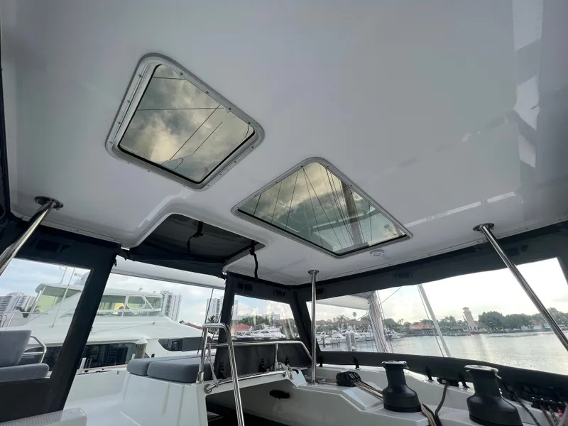 Slide: The Image of 2022 Fountaine Pajot Aura 51 catamaran docked at sunset with American flag. - 58