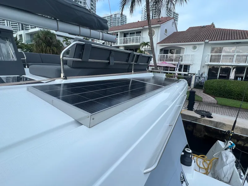 Slide: The Image of 2022 Fountaine Pajot Aura 51 catamaran docked at marina with cityscape background. - 62