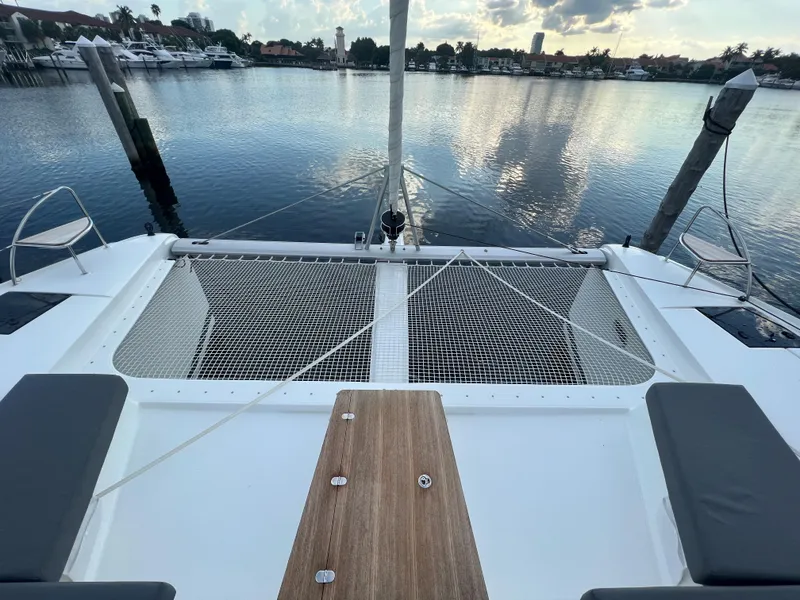 Slide: The Image of 2022 Fountaine Pajot Aura 51 catamaran docked in a marina, surrounded by sailboats. - 63