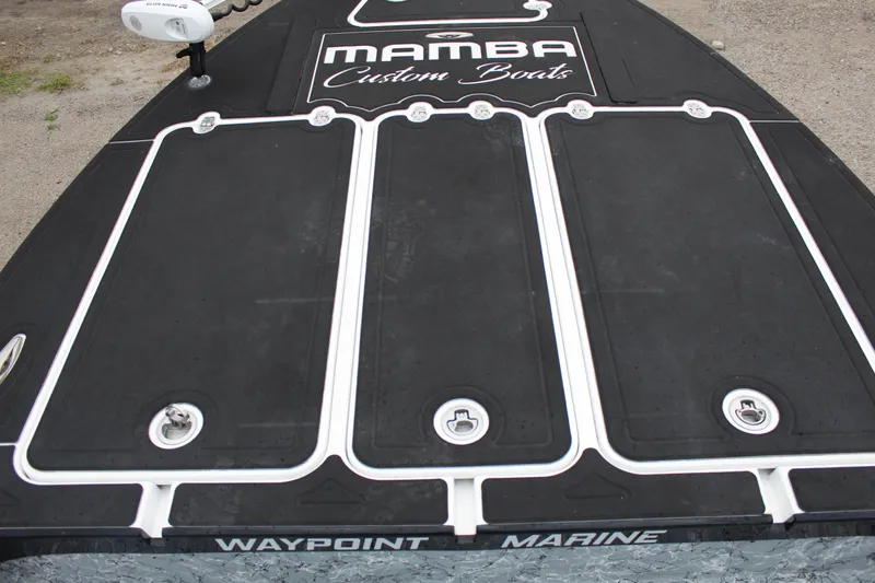 Slide: The Image of 2023 Mamba 227VX boat, black deck, custom design, parked outdoors. - 14