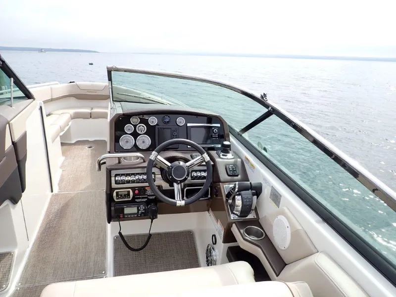 Slide: The Image of 2016 Formula 290 Bowrider boat interior with steering wheel and dashboard, on open water. - 16