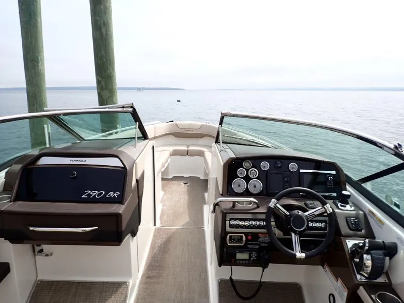 Slide: The Image of 2016 Formula 290 Bowrider boat interior with dashboard and steering wheel, overlooking calm waters. - 17