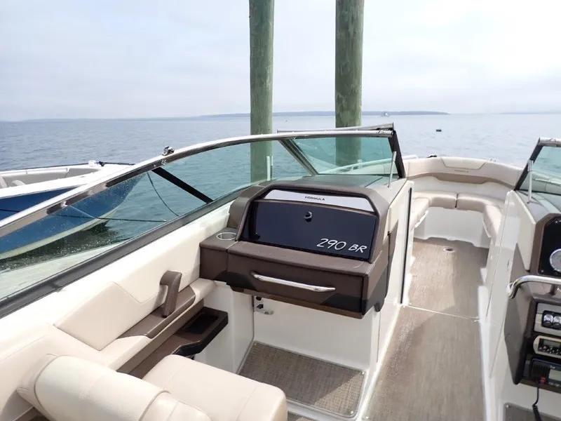 Slide: The Image of 2016 Formula 290 Bowrider boat interior with seating and dashboard, on calm water. - 18