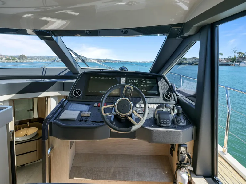 Slide: The Image of 2021 Absolute 50 Fly yacht helm with modern controls and scenic ocean view. - 34