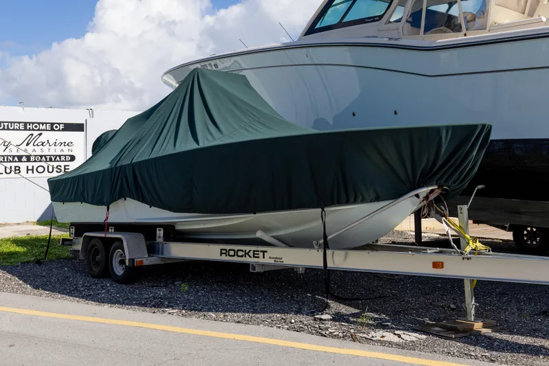 Slide: The Image of 1973 SeaCraft 20 boat covered on a trailer at a marina. - 10