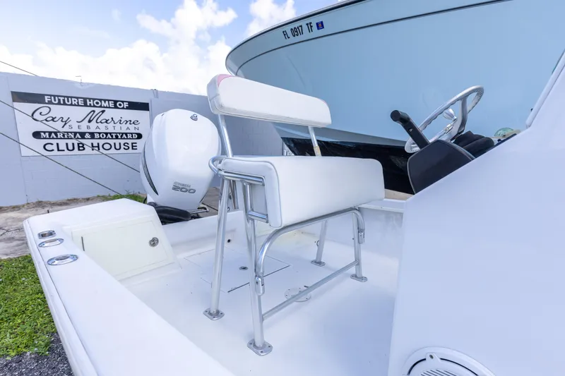 Slide: The Image of 1973 SeaCraft 20 boat interior with steering wheel and seat, near Cay Marine sign. - 4