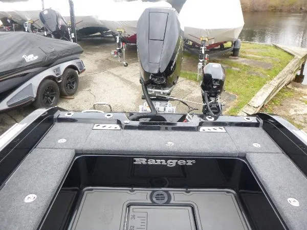 Slide: The Image of 2025 Ranger 622FS Pro boat with motor, docked near water, surrounded by other boats. - 14