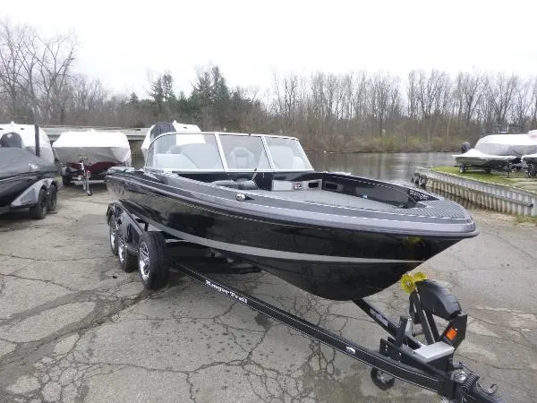 Slide: The Image of 2025 Ranger 622FS Pro boat on trailer, parked near a lake with other boats. - 6