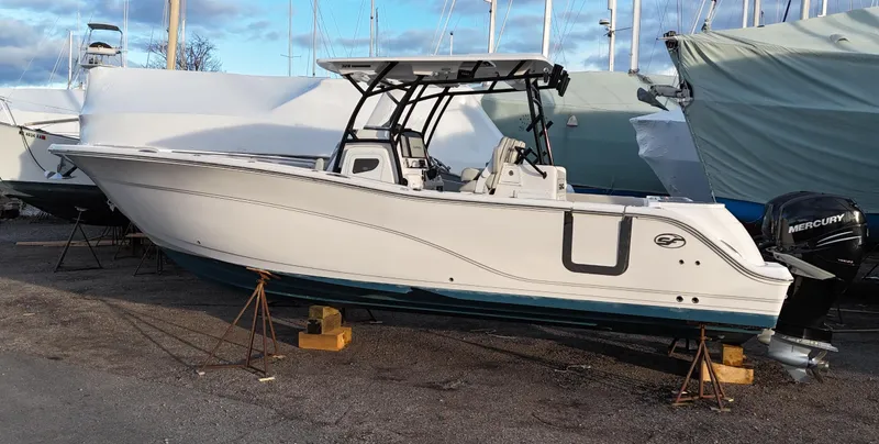 Slide: The Image of 2022 Sea Fox 328 boat on stands, with Mercury outboard motor, in a marina. - 2