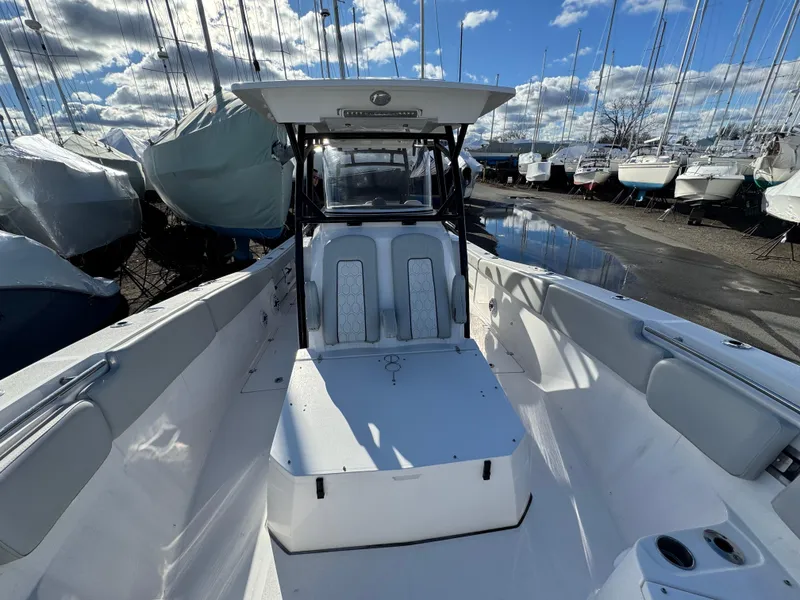 Slide: The Image of 2022 Sea Fox 328 boat with spacious deck, docked among sailboats under a cloudy sky. - 35