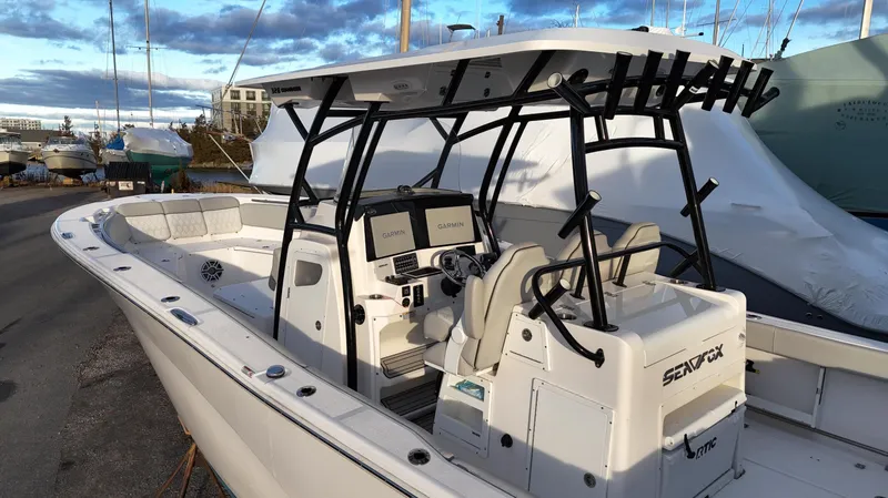 Slide: The Image of 2022 Sea Fox 328 boat with modern console and seating, docked under a cloudy sky. - 8