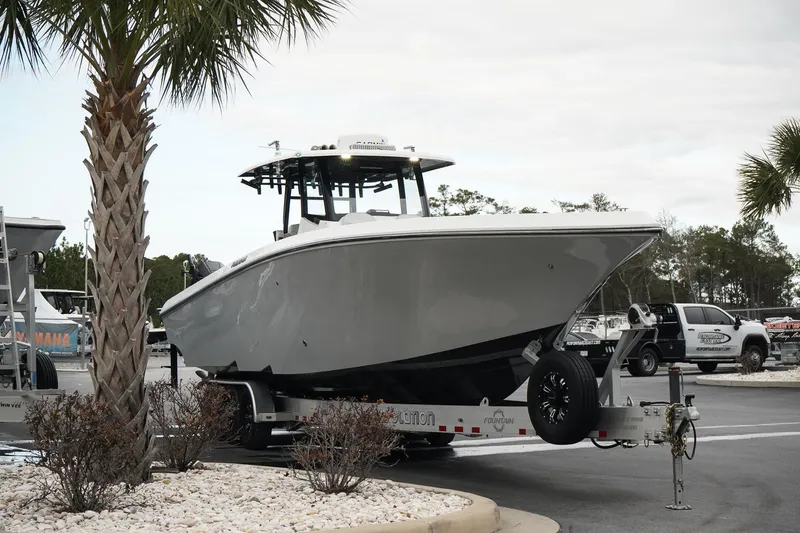 Slide: The Image of 2023 Fountain Bluewater 38 Tournament Edition boat on trailer, parked near palm trees. - 3