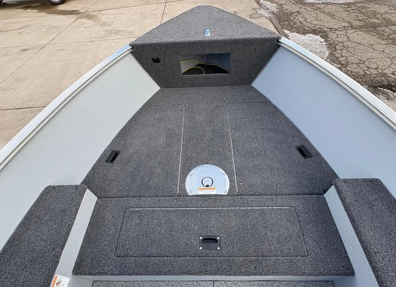 Slide: The Image of 2025 Lund 1600 Fury Tiller boat interior with gray carpeted deck. - 12