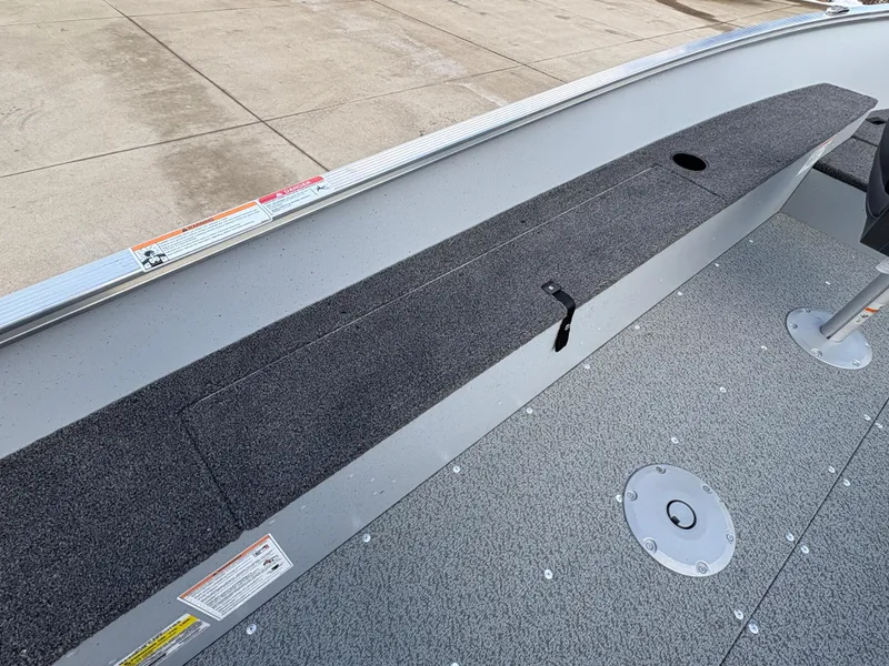 Slide: The Image of 2025 Lund 1600 Fury Tiller boat interior with carpeted storage and seating area. - 15