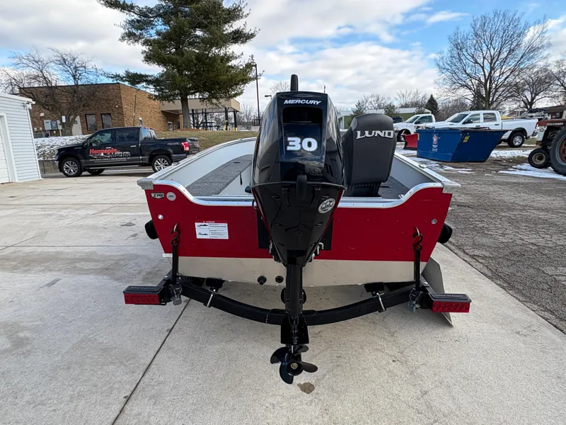 Slide: The Image of 2025 Lund 1600 Fury Tiller boat with Mercury 30 engine, parked outdoors. - 2