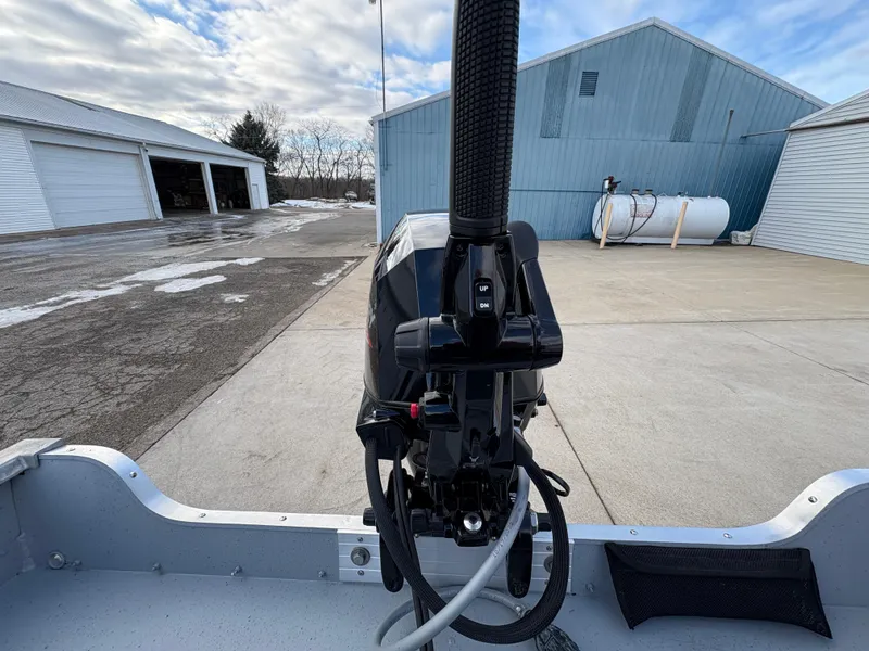 Slide: The Image of 2025 Lund 1600 Fury Tiller boat motor in a driveway with garages and a propane tank. - 22