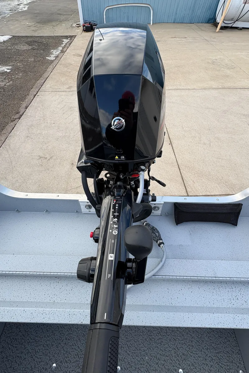 Slide: The Image of 2025 Lund 1600 Fury Tiller boat engine, sleek black design, outdoor setting. - 23