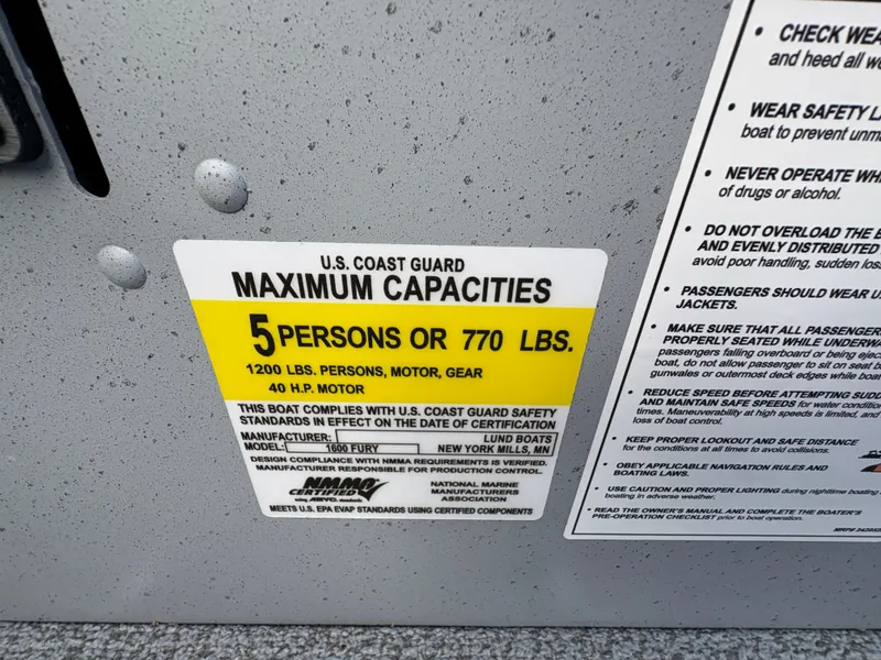 Slide: The Image of U.S. Coast Guard capacity label on 2025 Lund 1600 Fury Tiller boat, showing limits. - 24